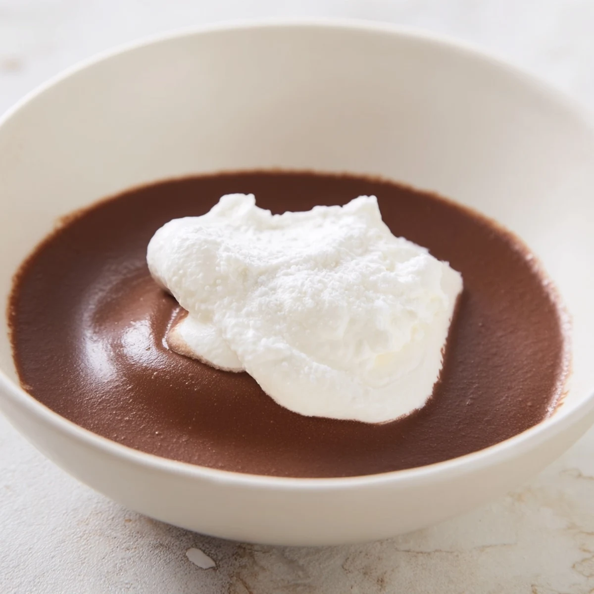 Clear glass dessert cups filled with rich, dark Chocolate Mousse with Whipped Cream, garnished with chocolate shavings.