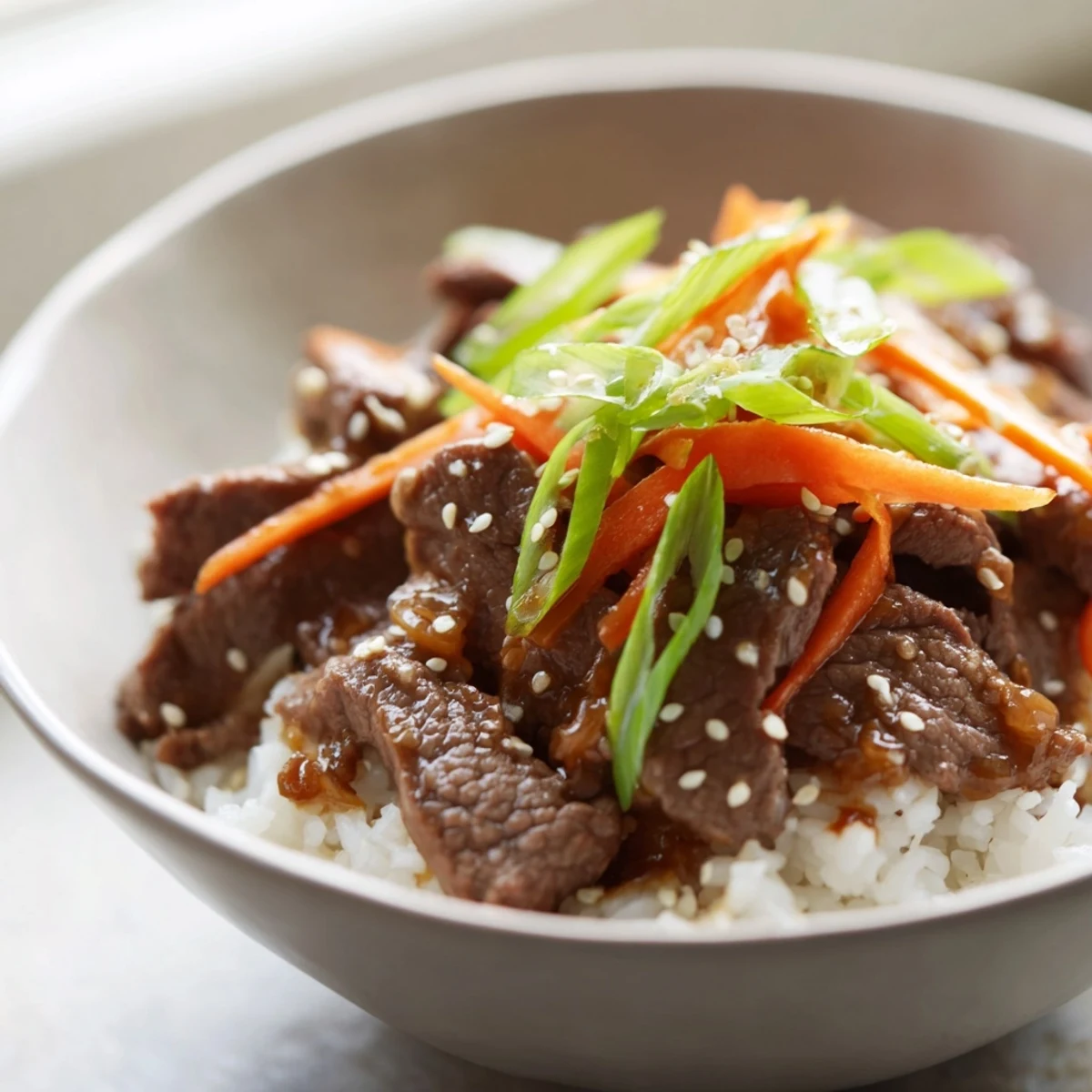 Beef Bowl with Steamed Rice served with chopsticks on a rustic wooden table, perfect for a quick dinner.