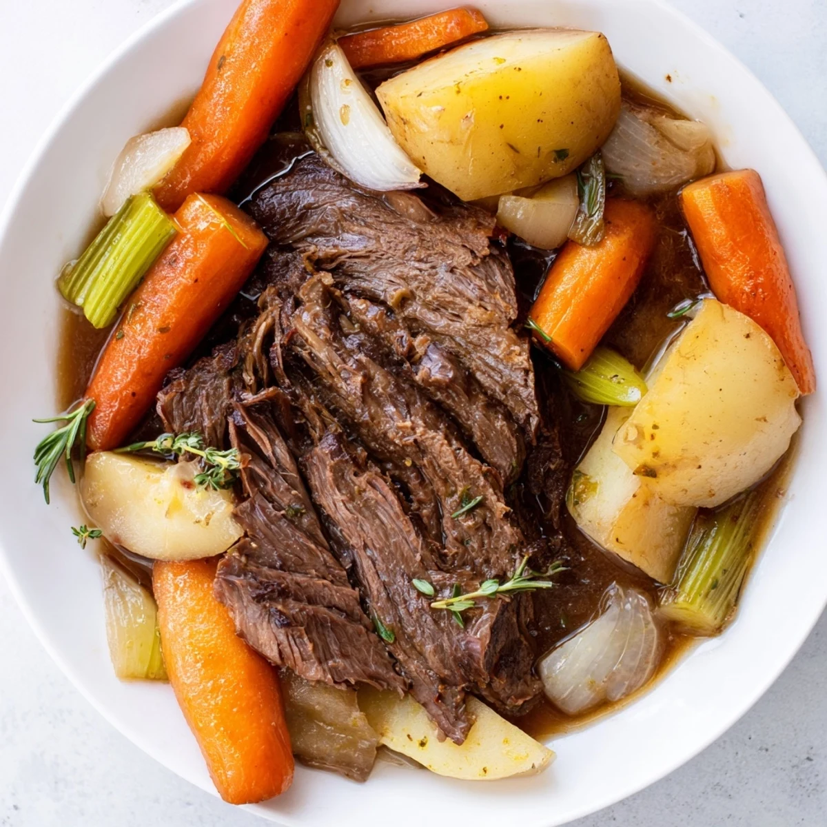 Family-style slow cooker pot roast plated with carrots, potatoes, and onions for a cozy dinner.