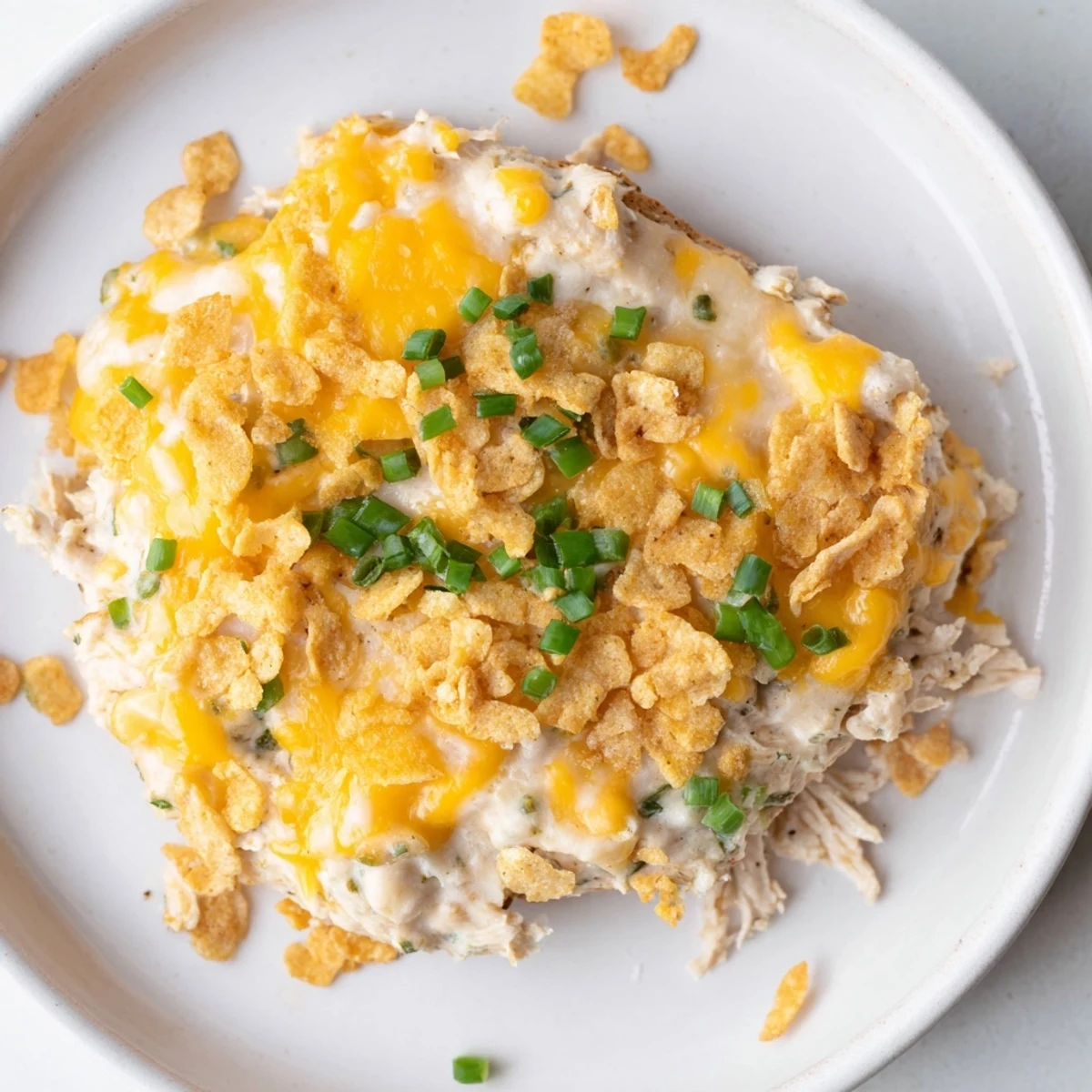 Juicy chicken breasts baked in creamy sour cream and onion sauce, topped with melted cheddar and fresh green onions.