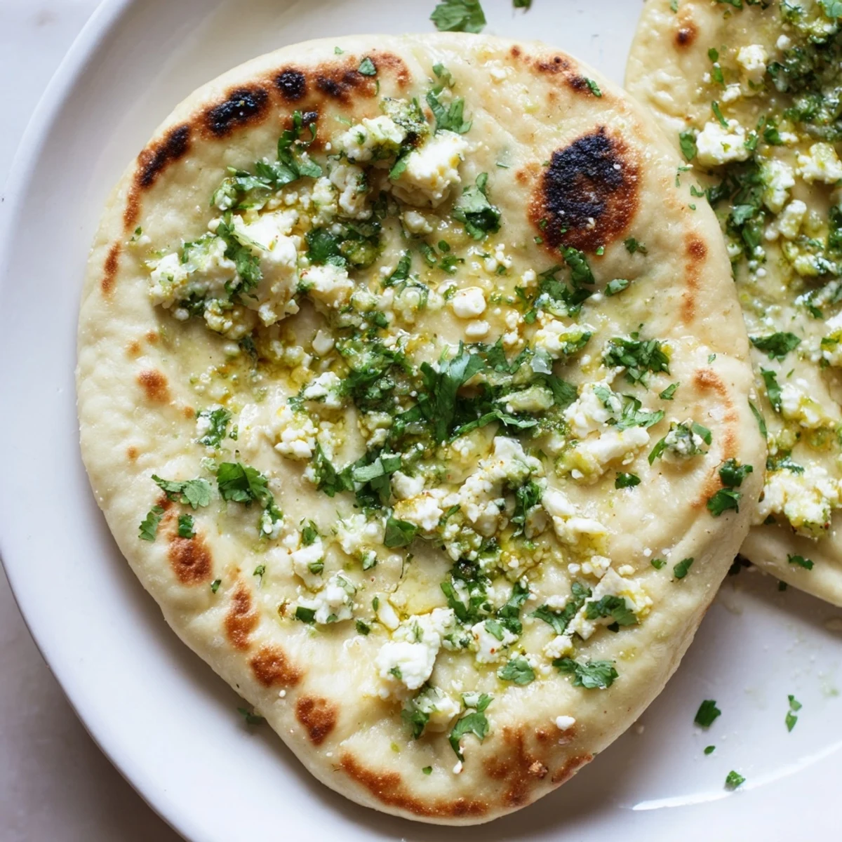 Golden-brown Cottage Cheese Garlic Naan fresh off the skillet, brushed with melted butter and herbs.  