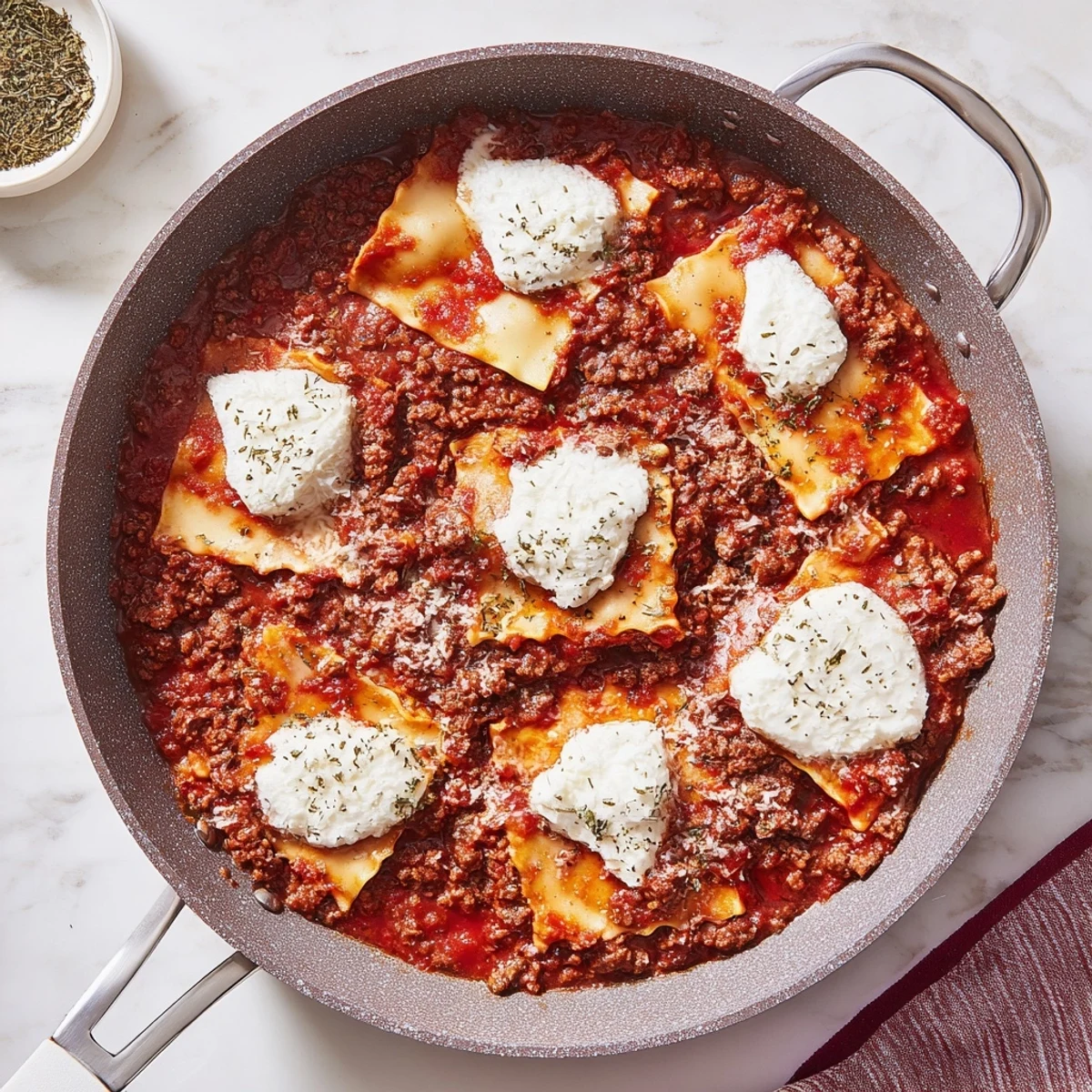 Golden-brown Cheats Frypan Lasagne in a skillet with melted mozzarella, ricotta dollops, and fresh basil garnish, served with a green salad.