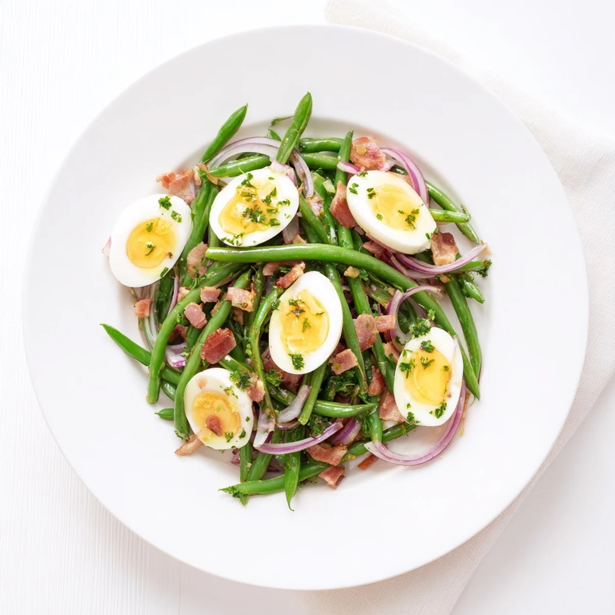 A close-up of the Green Bean, Bacon, and Egg Salad showing crisp beans, smoky bacon, and halved eggs on a white platter.