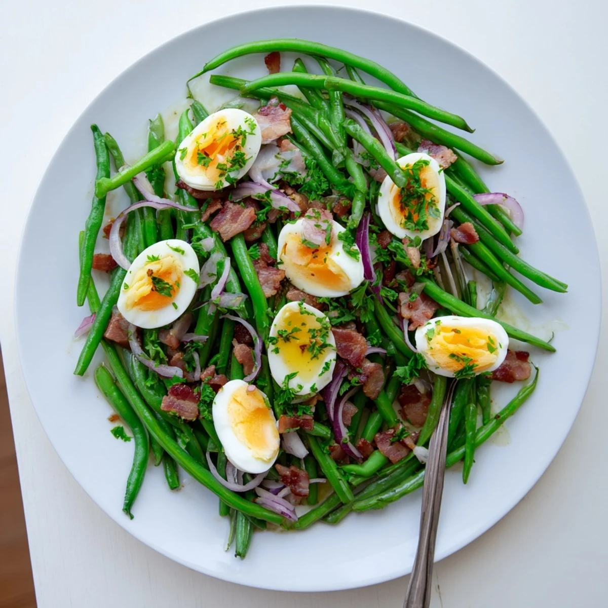 Freshly prepared Green Bean, Bacon, and Egg Salad garnished with parsley, ready for a light lunch or hearty side dish.