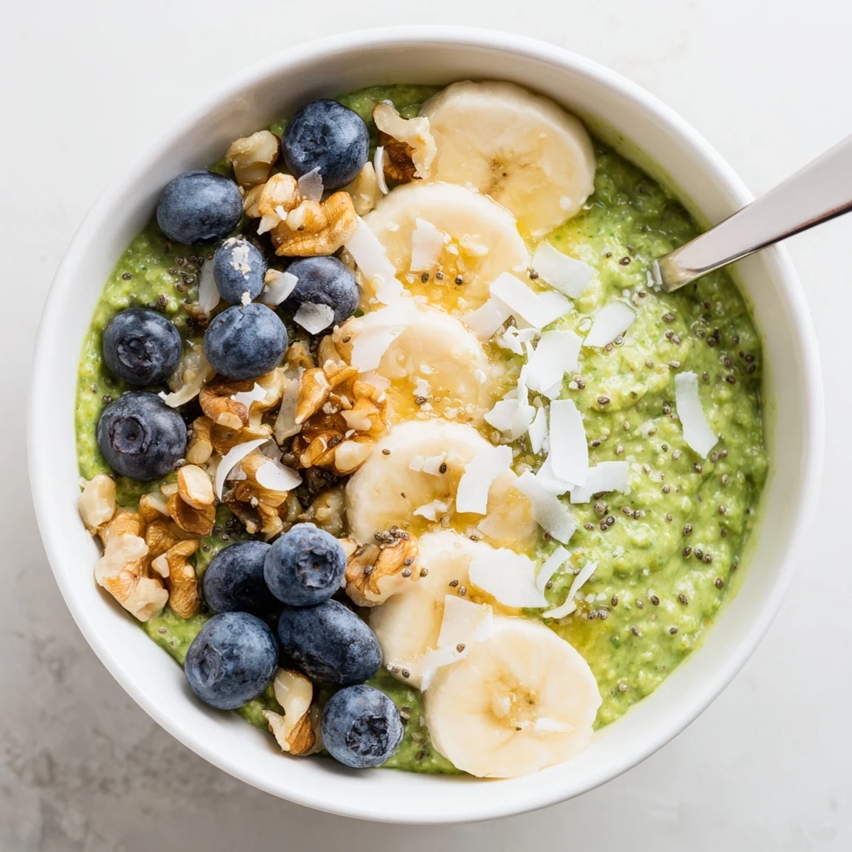 Creamy Matcha Protein Overnight Oats topped with fresh berries and banana in a glass jar.