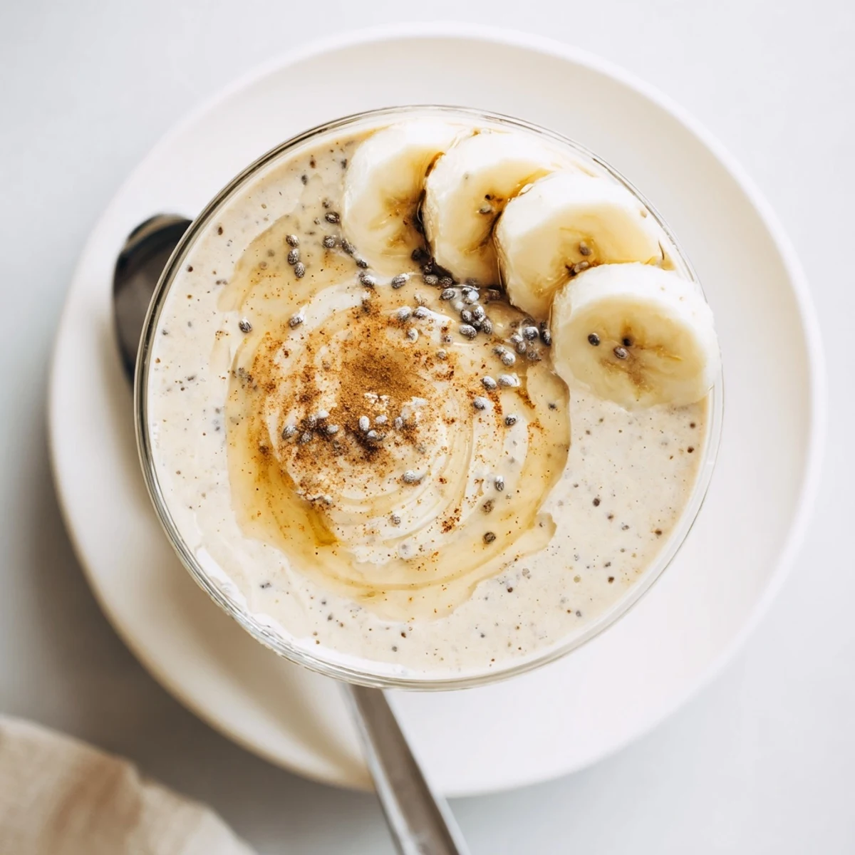 Thick and velvety Greek yogurt banana smoothie blended with ice and drizzled with honey