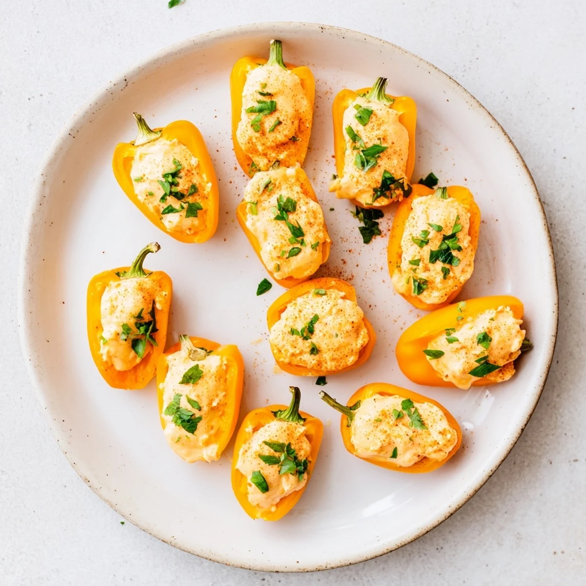 Crispy air fryer cream cheese stuffed mini peppers topped with paprika, served warm as appetizer