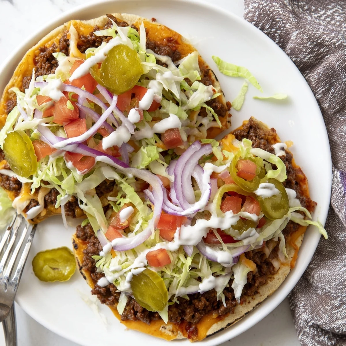 Homemade smash burger tacos loaded with fresh lettuce, diced tomatoes, and zesty special sauce
