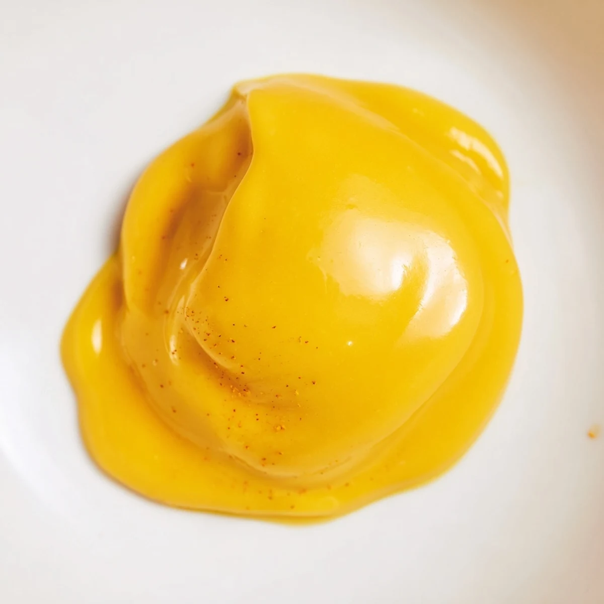 Creamy yellow easy vegan mango curd spread generously on toasted sourdough bread slice