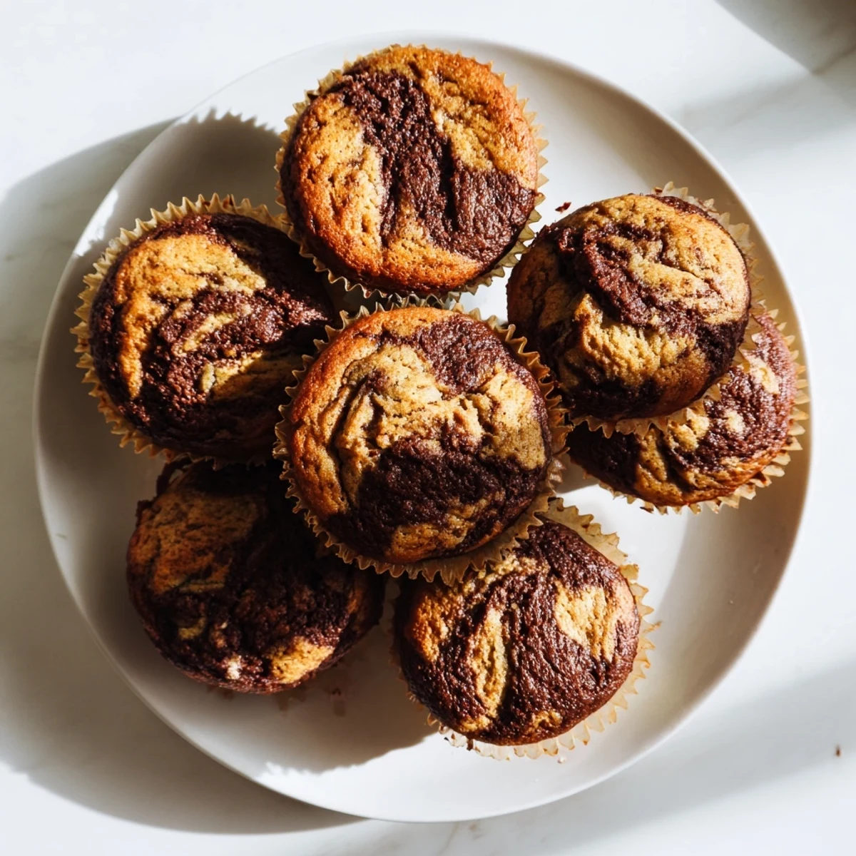 Freshly baked Nutella banana muffins with gooey chocolate hazelnut centers ready for breakfast