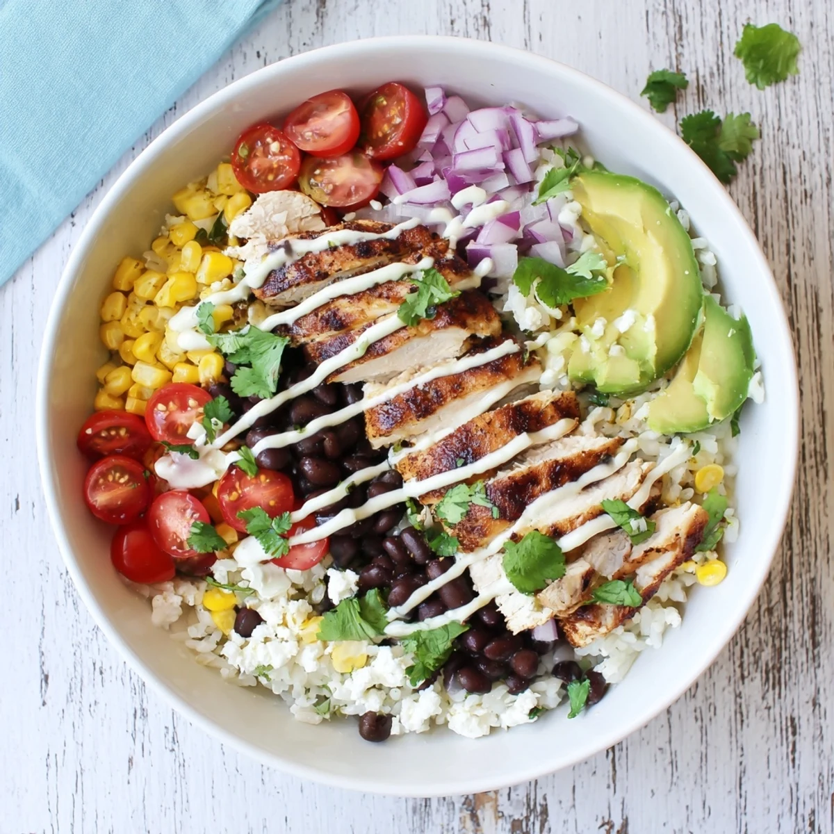Vibrant Baja style chicken bowl with grilled chicken, fresh avocado, colorful veggies and creamy chipotle drizzle