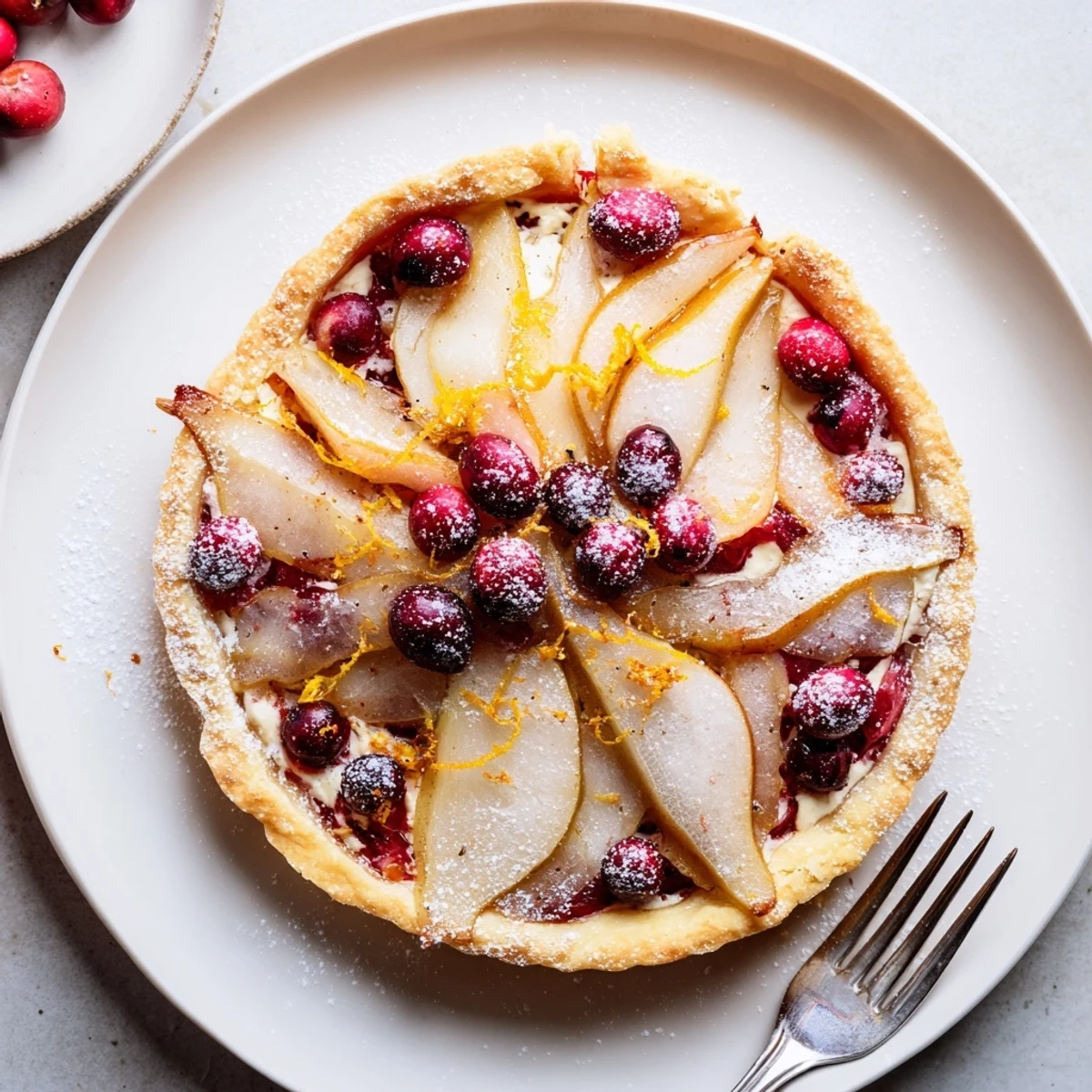 Homemade cranberry tart featuring ripe pear slices bubbling beneath golden demerara sugar on autumn table