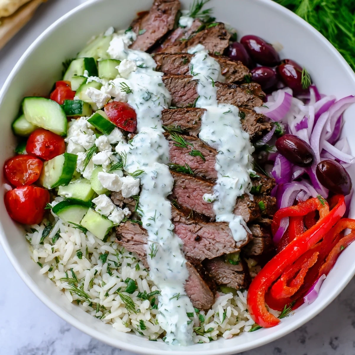 Vibrant Mediterranean steak bowl arranged with tender sliced steak, herbed basmati rice, crumbled feta cheese, roasted red peppers, and refreshing crisp toppings