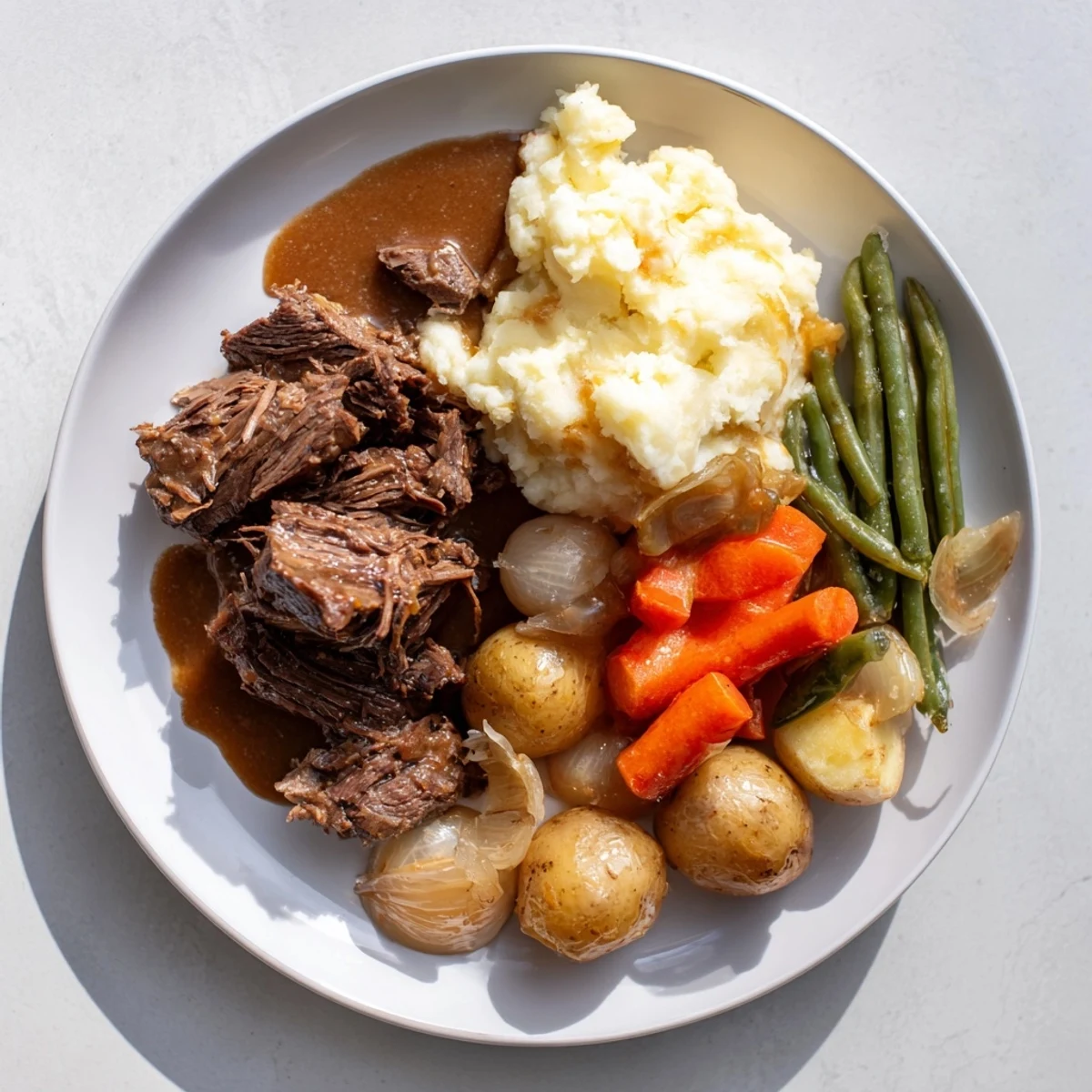 Golden brown Southern style pot roast with tender beef, carrots, and celery in rich dark gravy
