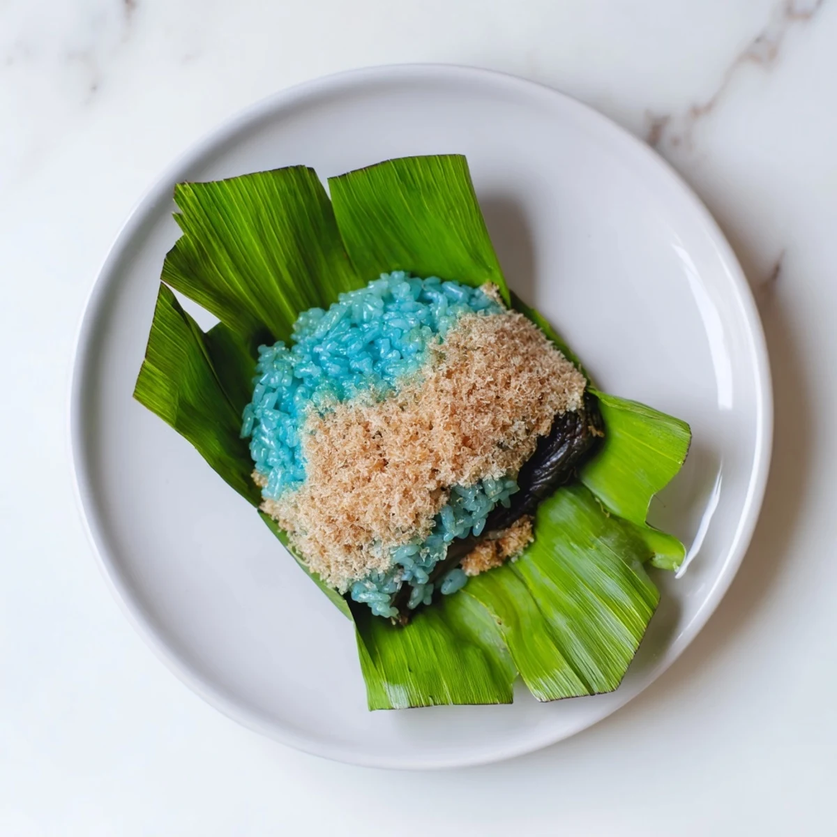 Steamed Malaysian Pulut Inti featuring fluffy glutinous rice topped with sweet coconut palm sugar mixture