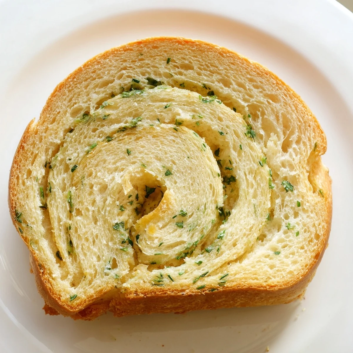 Freshly baked garlic and herb bread with golden crust and soft parsley flecked texture