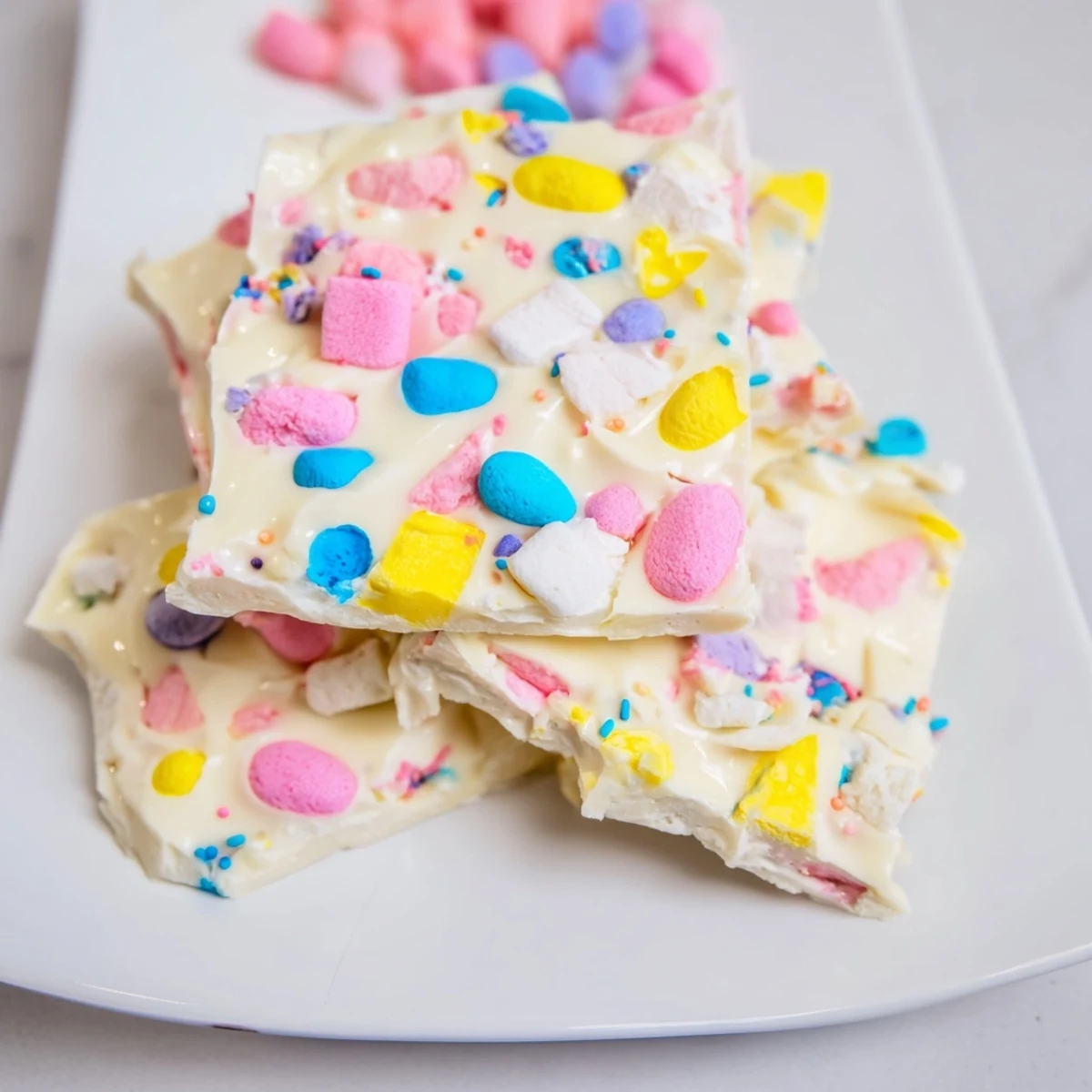 White chocolate Easter marshmallow bark topped with pastel candy eggs and colorful sprinkles