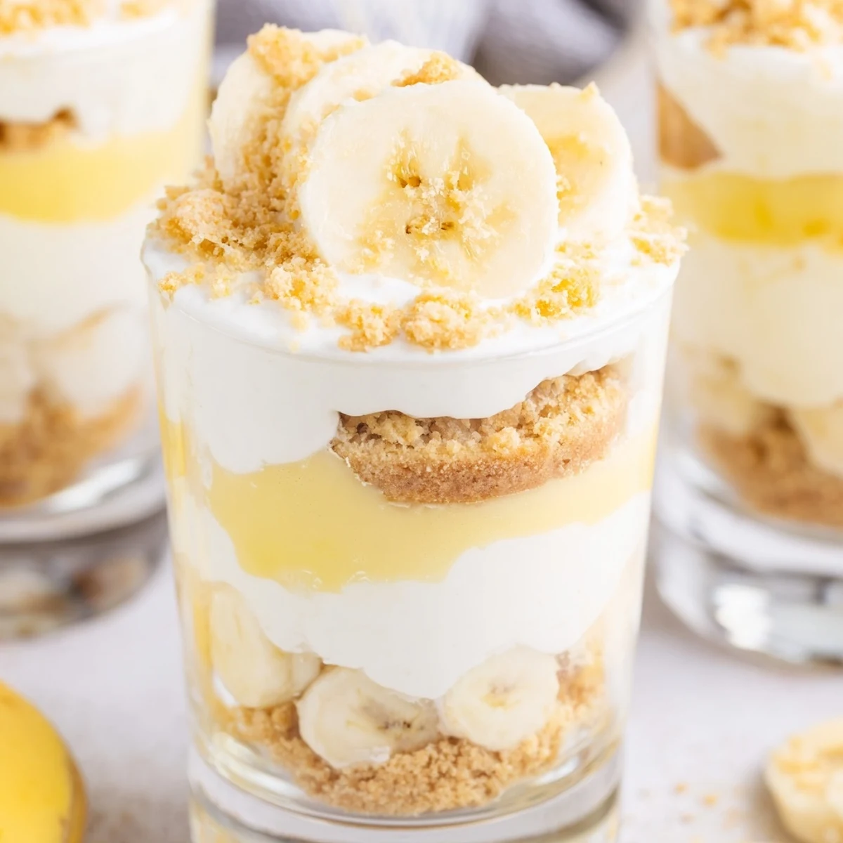 Individual no bake banana pudding cheesecake cups topped with fresh banana slices