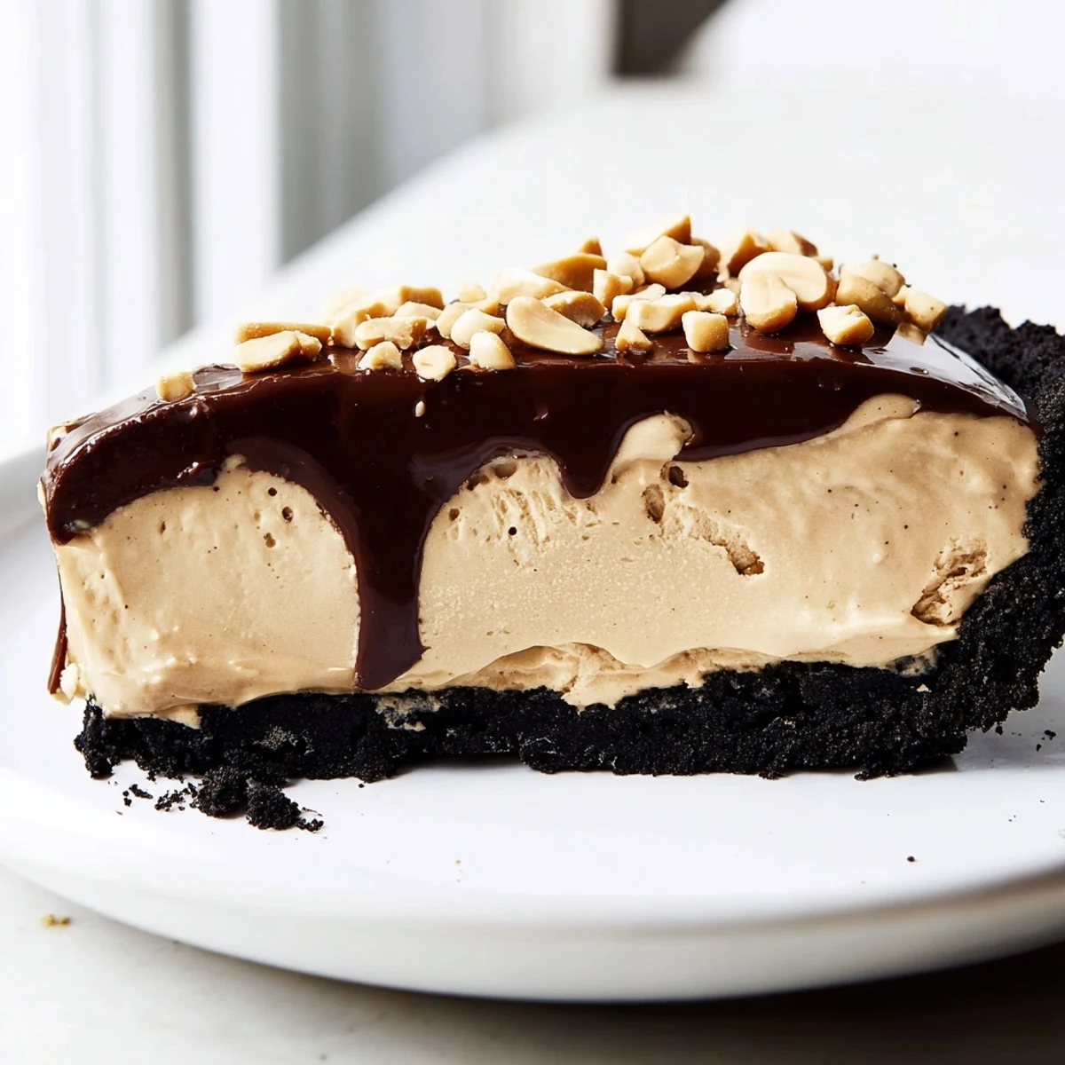 No bake peanut butter pie with glossy chocolate ganache drizzle and chopped peanut topping