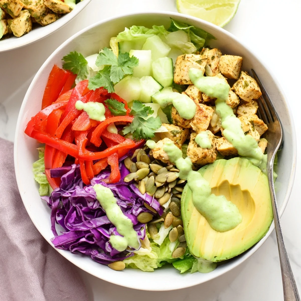 Fresh low-carb keto bowls featuring grilled chicken, vibrant veggies, and drizzled avocado lime dressing