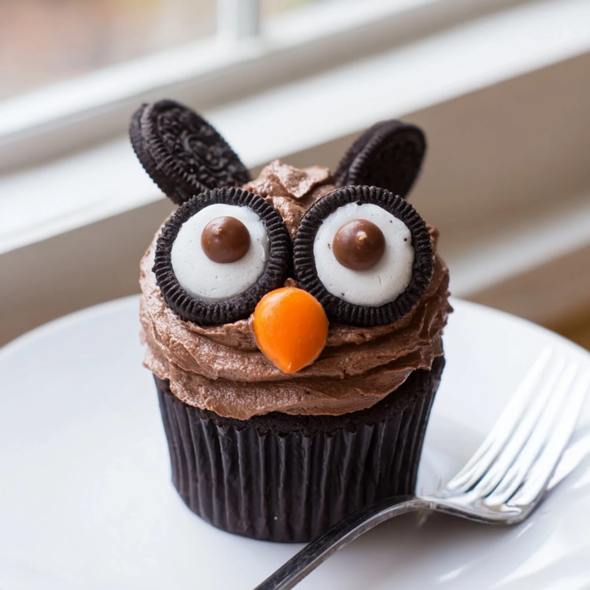 Chocolate Oreo Owl Cupcakes with creamy frosting and candy beaks displayed on a white platter