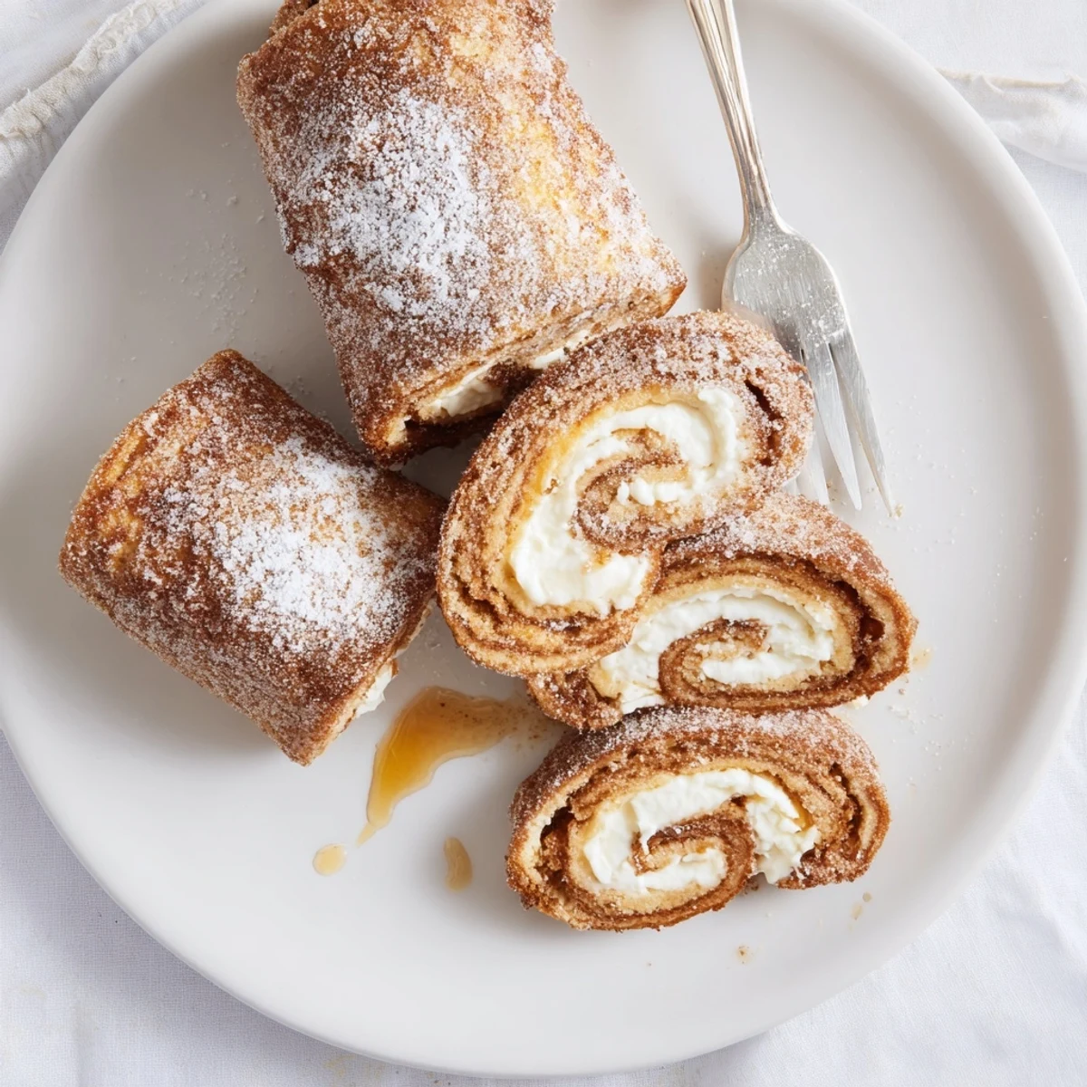 Handheld Cinnamon Roll French Toast Roll Ups with creamy filling, perfect for brunch