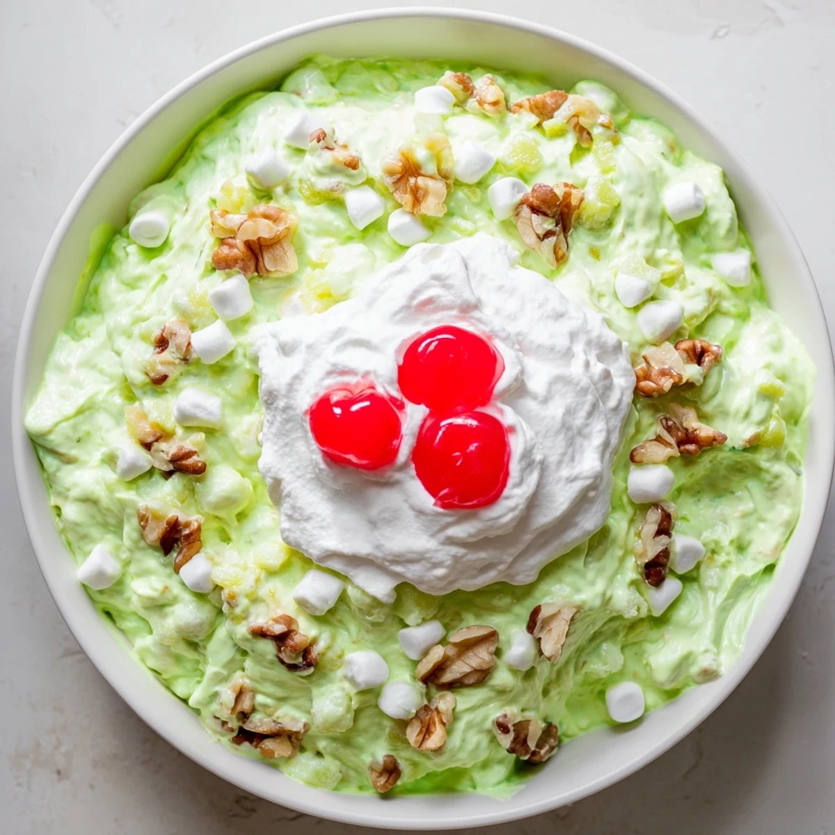 Vintage Watergate Salad recipe displaying fluffy bright green pistachio mixture with marshmallows and crushed pineapple in a glass serving bowl