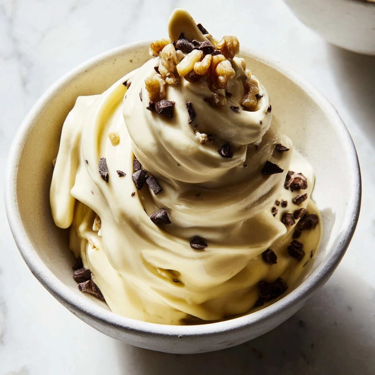Silky smooth vegan banana nice cream served in a chilled bowl with a wooden spoon ready to scoop
