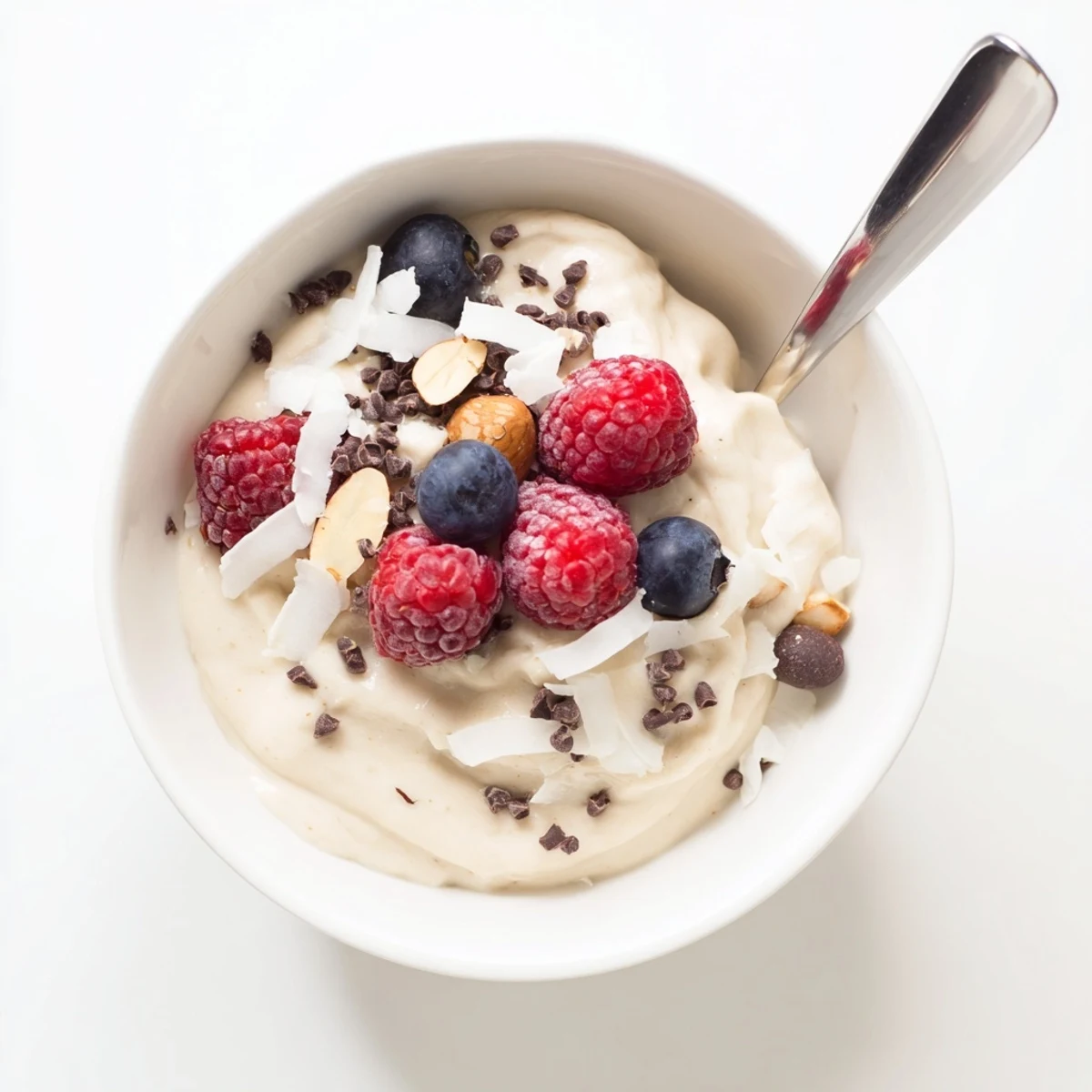 Dairy-free healthy nice cream recipe scooped into a glass bowl with chopped nuts topping