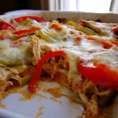 Hearty chicken fajita casserole topped with melted Mexican cheese over sautéed bell peppers and onions