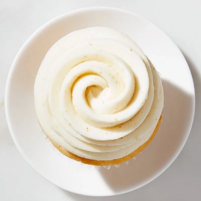 Light and fluffy homemade vanilla cupcakes with tall peaks of vanilla buttercream served on a white platter