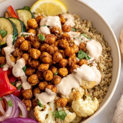 Vibrant Moroccan chickpea bowl topped with fresh herbs and zesty tahini drizzle